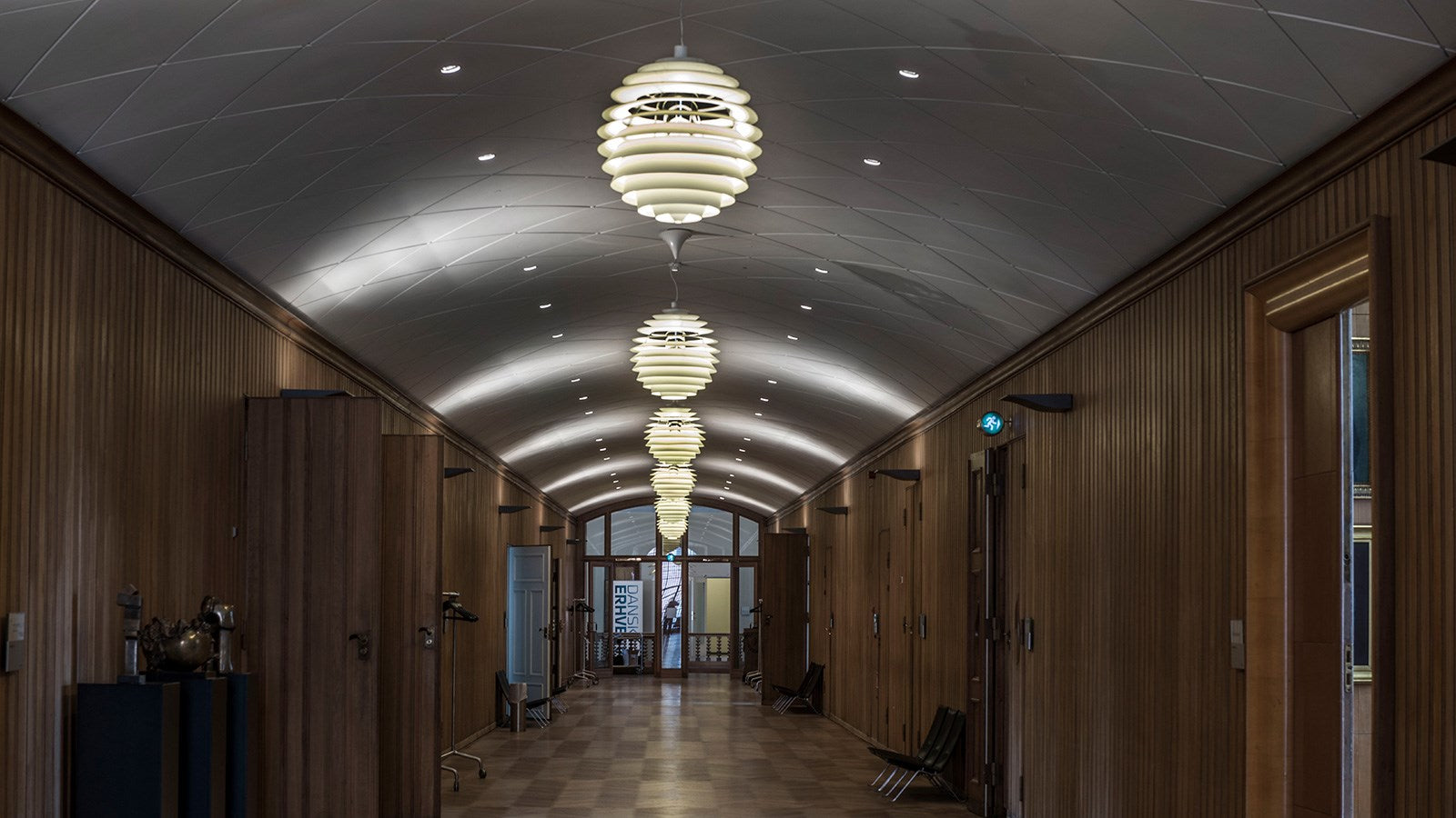 Plusieurs luminaires suspendus un à la suite de l'autre dans un hall d'entrée